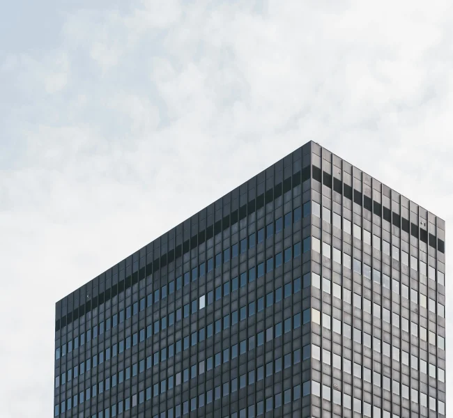 Hohes Bürogebäude mit dunkler Glasfassade, Perspektive von unten